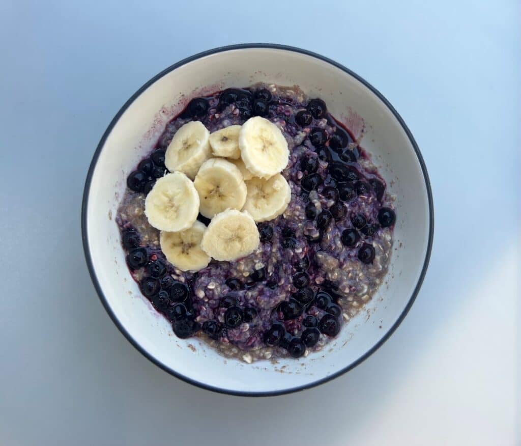 Bowl of blueberry oatmeal with sliced banana on top