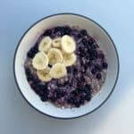 Bowl of blueberry oatmeal with sliced banana on top