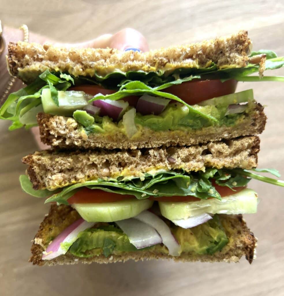 Kidney friendly veggie sandwich sliced in half showing the veggies inside.