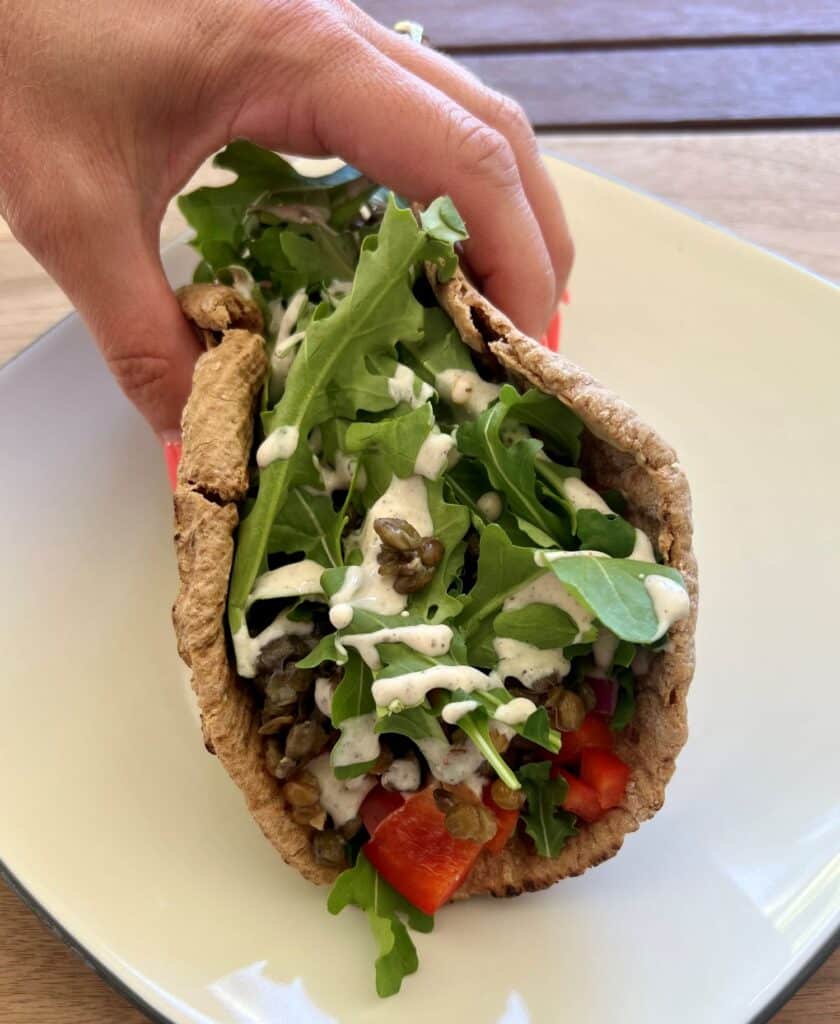 Pita Wrap Recipe with lentils, veggies, and yogurt dressing folded inside.