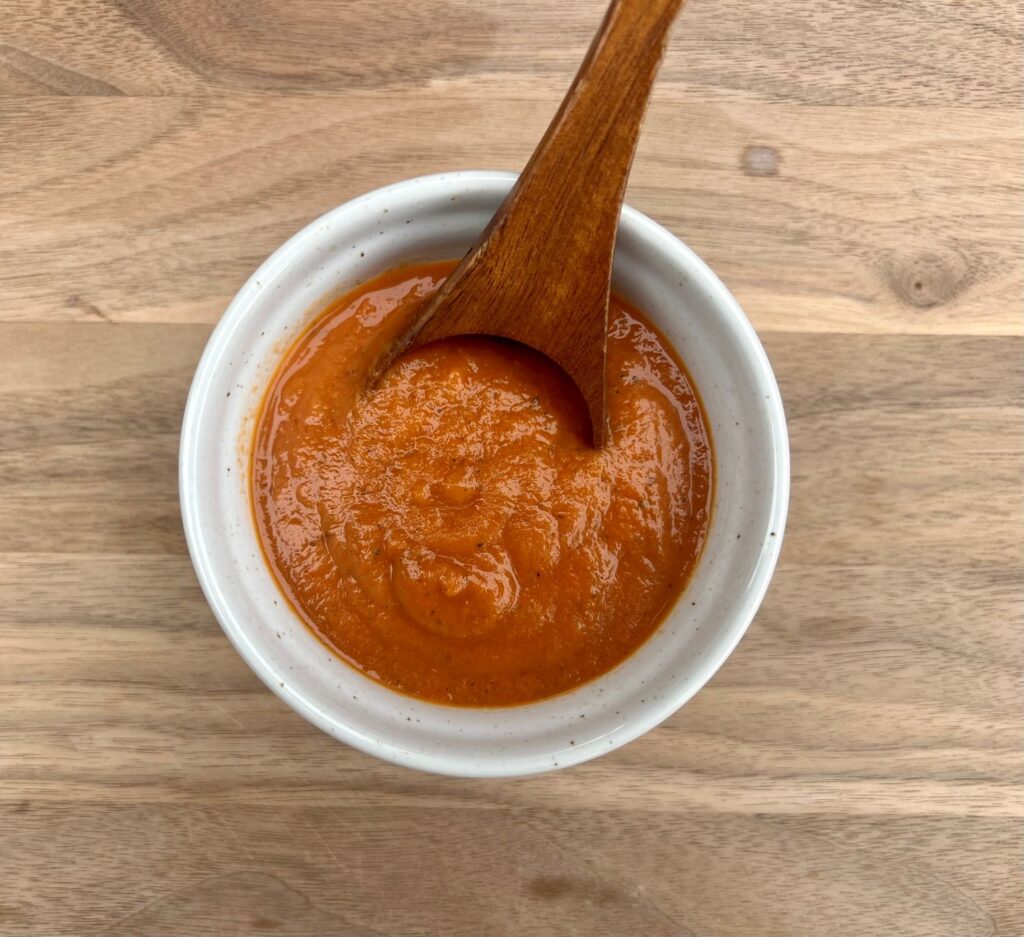 Low sodium roasted veggie pasta sauce in a bowl with a spoon.