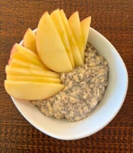 Bowl of overnight apple cinnamon oatmeal with sliced apples on top.