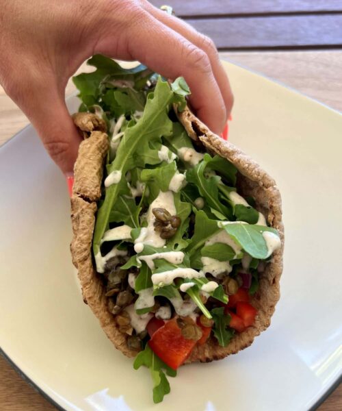 Pita Wrap Recipe with lentils, veggies, and yogurt dressing folded inside.