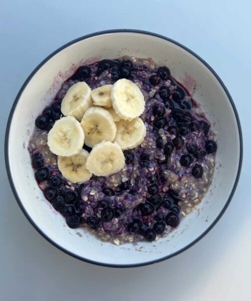 Bowl of blueberry oatmeal with sliced banana on top