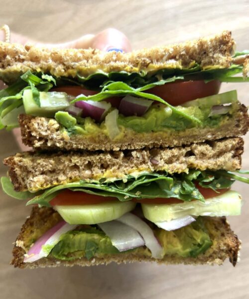 Kidney friendly veggie sandwich sliced in half showing the veggies inside.